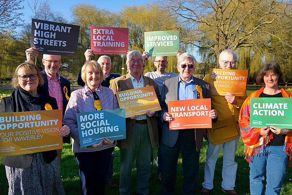 Waverley Lib Dem candidates in the Godalming Burys field, holding signs with the "Building Opportunity" manifesto pledges