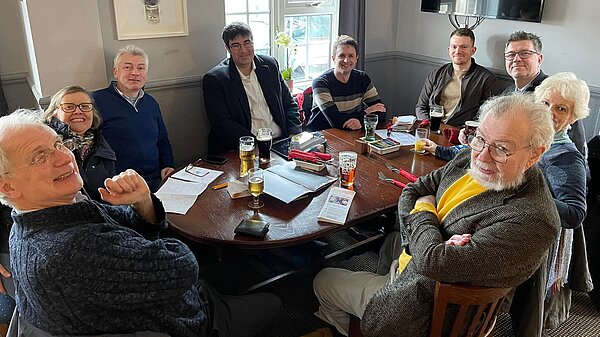 Lib Dem members chatting around a table in a pub