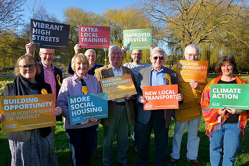 Waverley Lib Dem candidates in the Godalming Burys field, holding signs with the "Building Opportunity" manifesto pledges